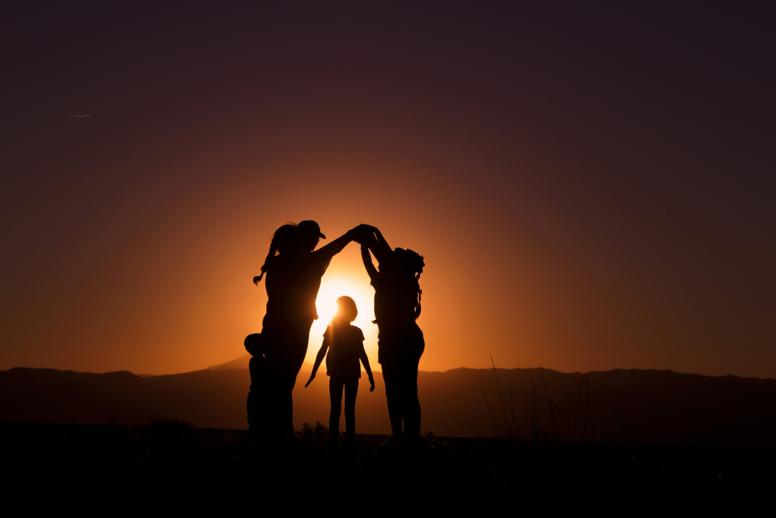 a group of people standing in front of a sunset